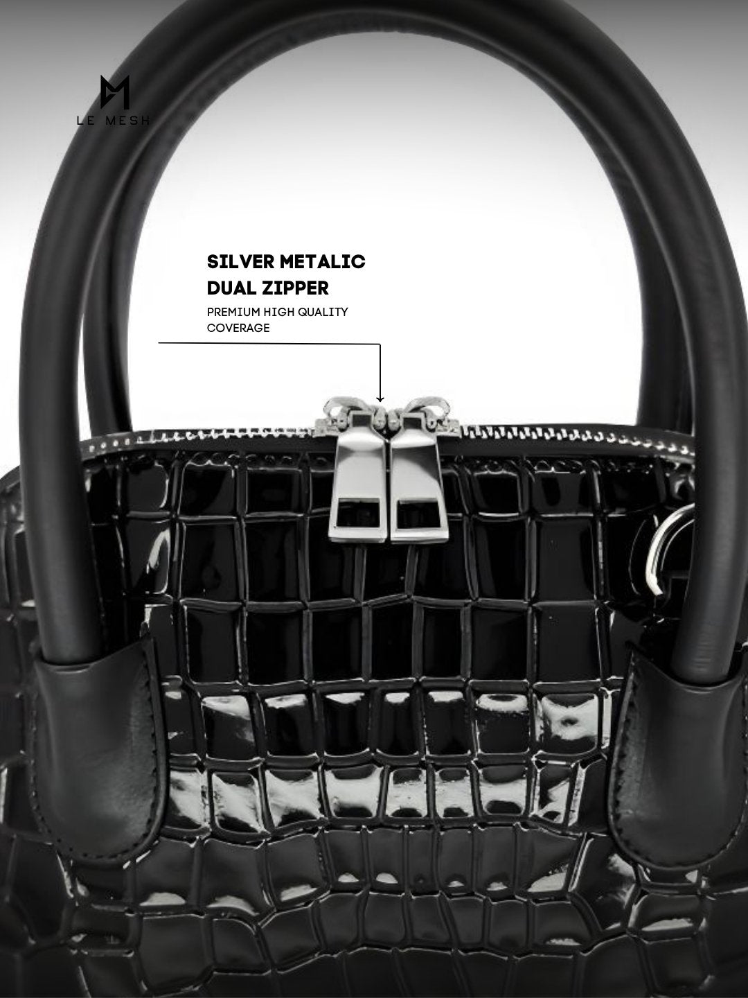 Black handbag with silver metallic dual zipper on a light gray background
