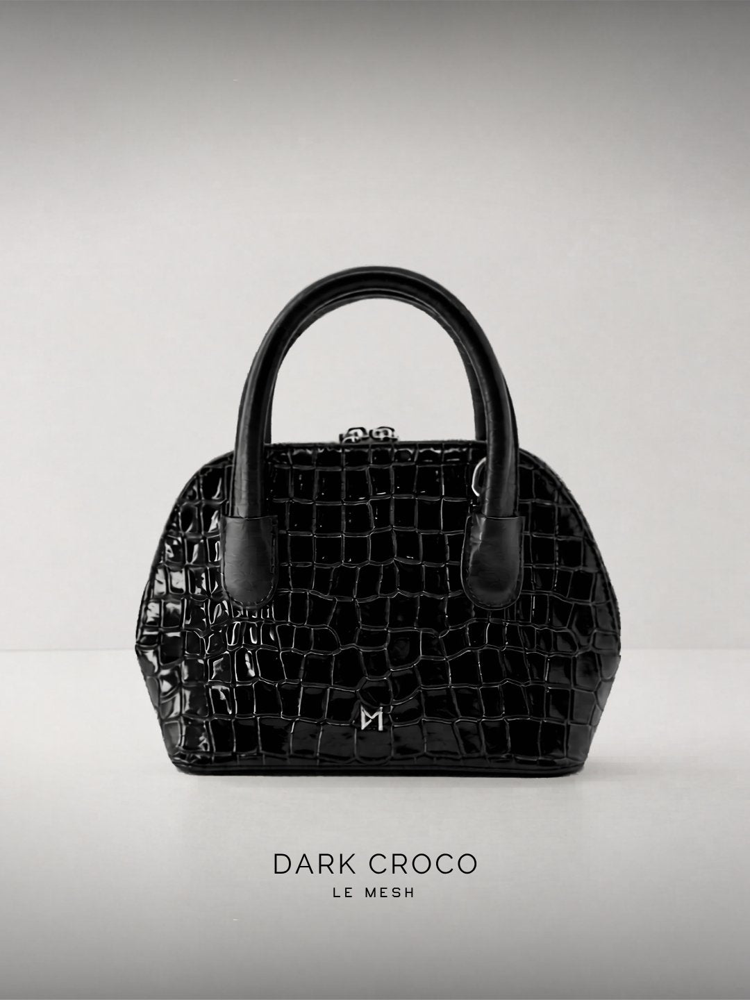 Black Crocodile textured Leather handbag on a light gray background
LE MESH Dark Croco structured black crocodile-embossed leather top-handle bag.
Minimalist black crocodile-embossed leather handbag by LE MESH with silver hardware