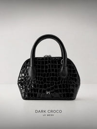 Black Crocodile textured Leather handbag on a light gray background
LE MESH Dark Croco structured black crocodile-embossed leather top-handle bag.
Minimalist black crocodile-embossed leather handbag by LE MESH with silver hardware