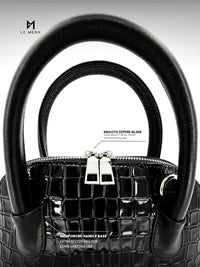Black handbag with detailed text on features against a white background