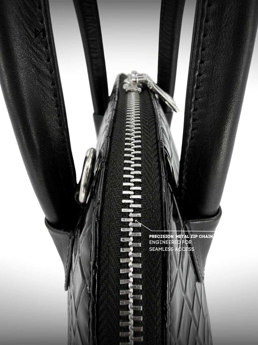 Close-up of a black tire with a zipper running along its side, on a white background.