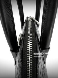 Close-up of a black tire with a zipper running along its side, on a white background.