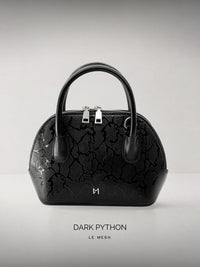 Black handbag with 'Dark Python' pattern on a light gray background
Black textured handbag with silver hardware on a light gray background